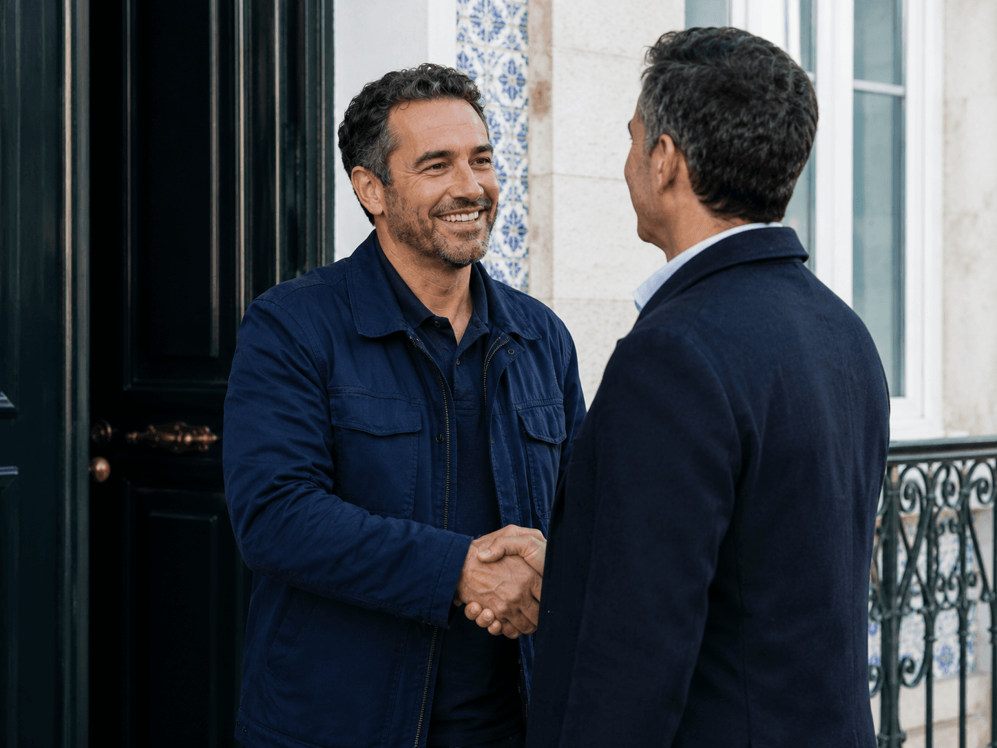 Um profissional cumprimenta um cliente à porta de casa